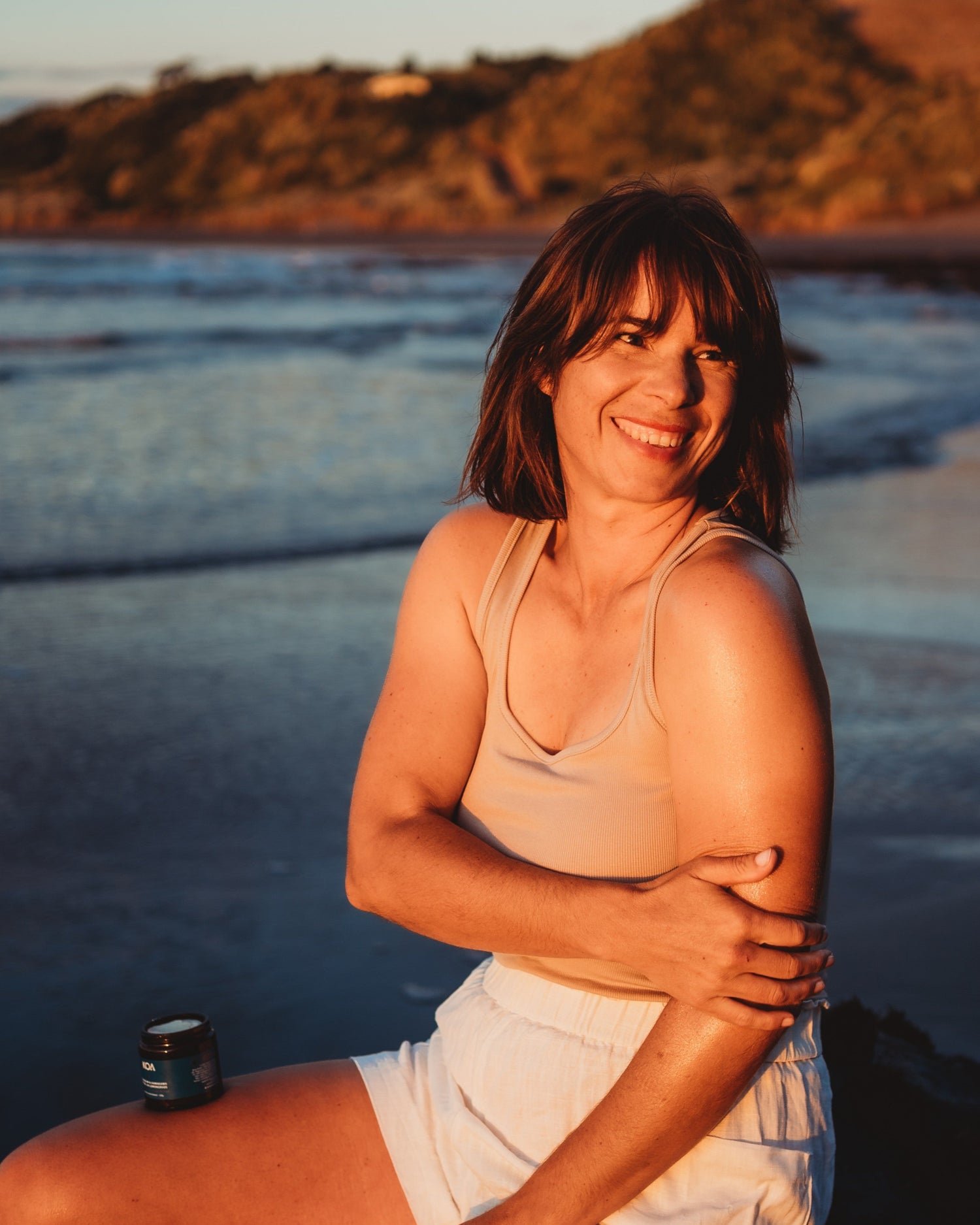 woman by ocean rubbing magnesium on body