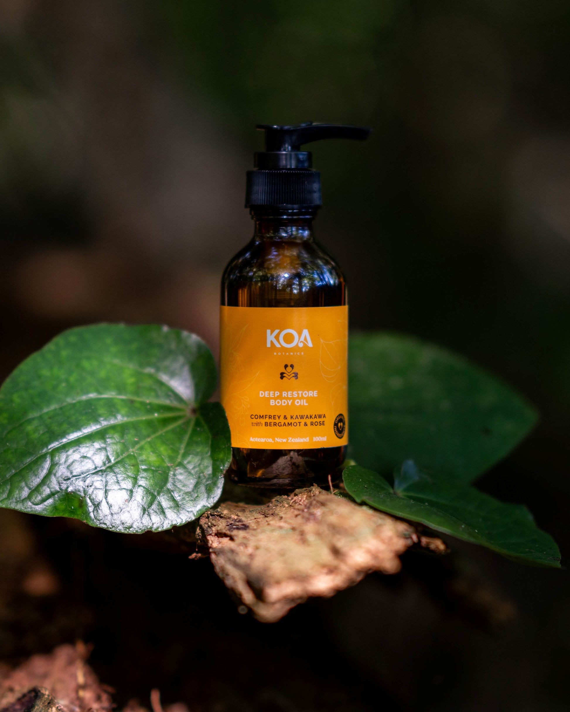 Bottle of KOA oil on a leaf with a blurred natural background