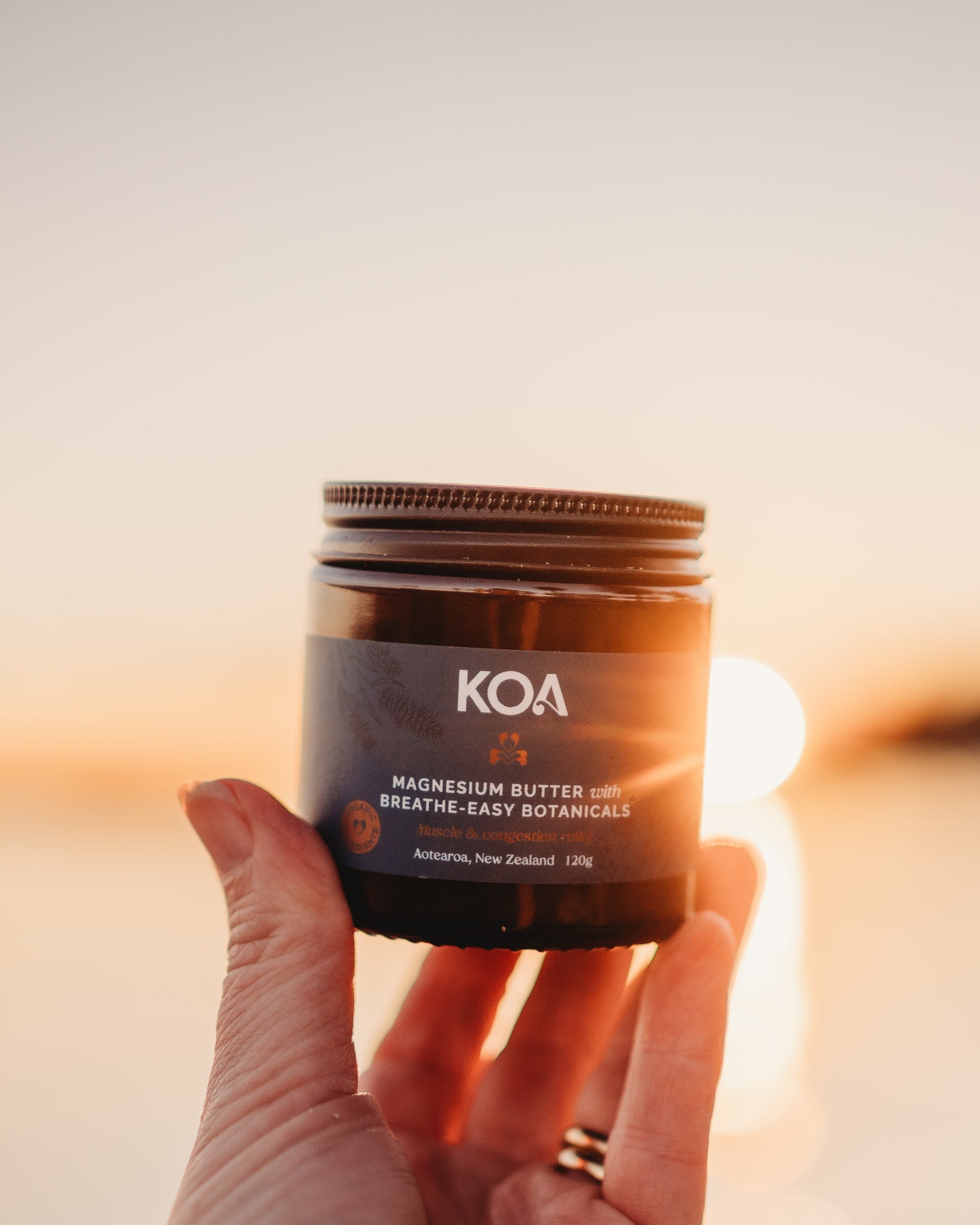 Koa breath easy magnesium butter in hand held up to sun behind. Buy Magnesium online