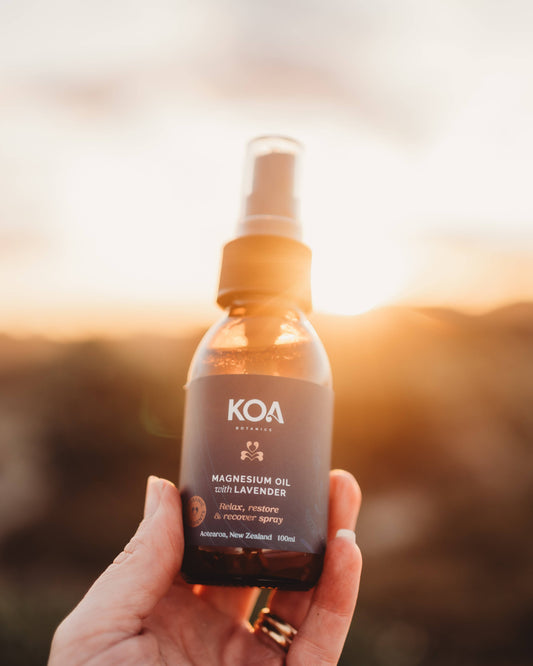 Magnesium Oil with Lavender being held in a hand with a scenic background.