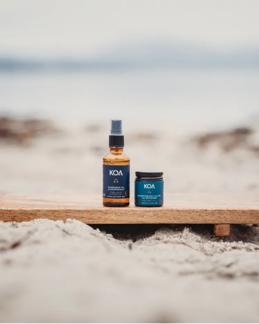 Magnesium Butter with Peppermint sitting on a sand with ocean background.